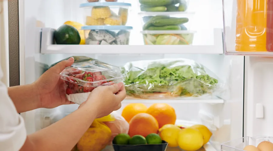 Organized refrigerator with fresh fruits and vegetables.