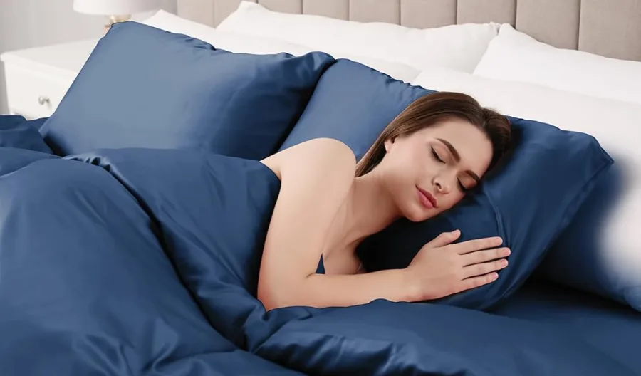 Woman sleeping on blue silk sheets.