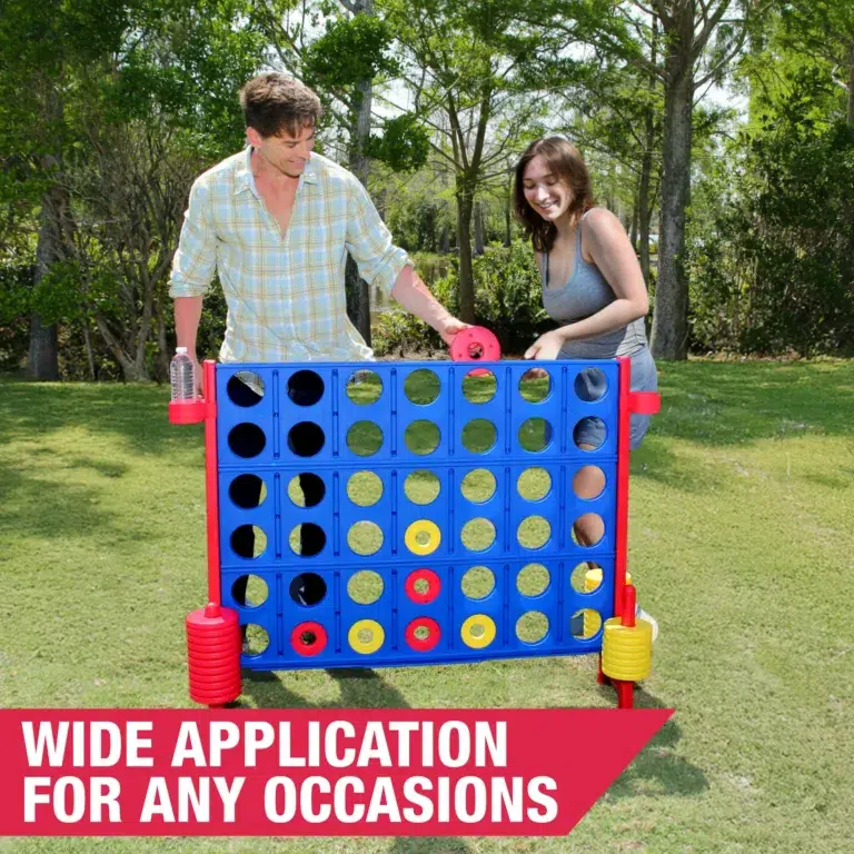 People playing giant Connect Four game outdoors.