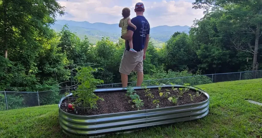Father and child enjoy mountain view by garden.