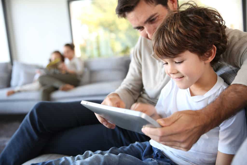 father and son playing with digital tablet