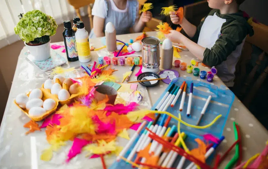 Kids crafting with colorful materials and supplies.