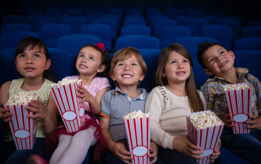 Children enjoying popcorn at the movie theater.