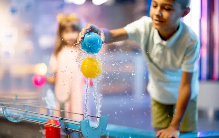 Children playing with water and colorful balls.