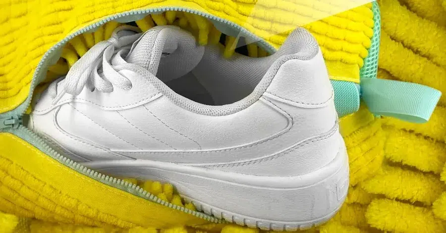 White sneaker inside yellow zipper bag