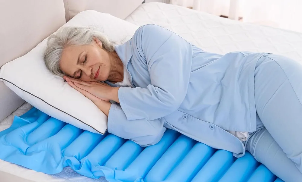 Woman sleeping on blue air mattress in bed.