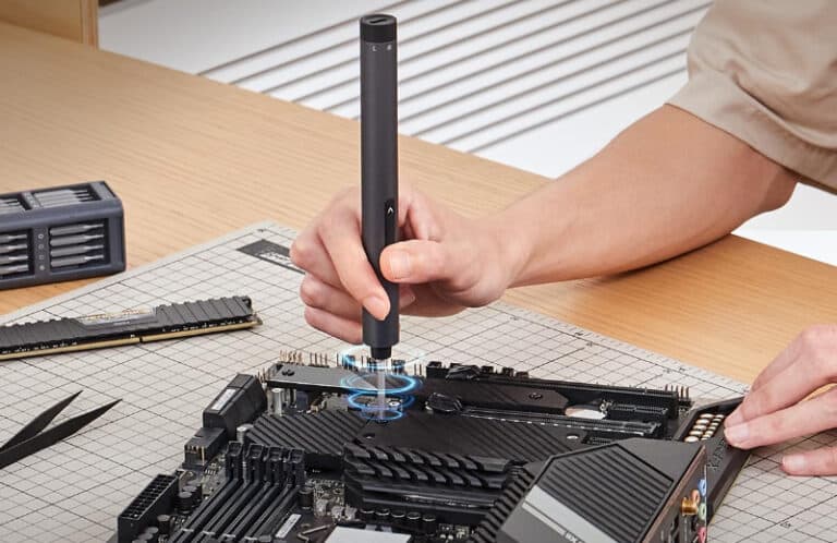 Person assembling computer motherboard with screwdriver.