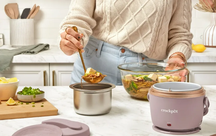 Woman ladling soup into stainless container.
