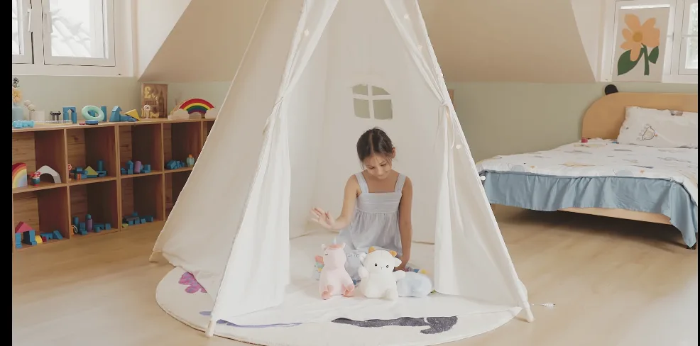 Child playing with stuffed animals in a teepee.