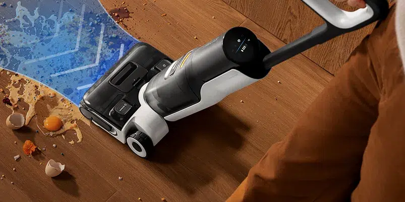 Vacuum cleaner cleaning spilled food on floor.