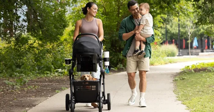 Family walking with stroller and toddler on path.
