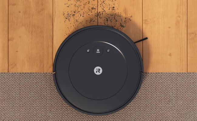 Robot vacuum cleaning dirt on hardwood floor.