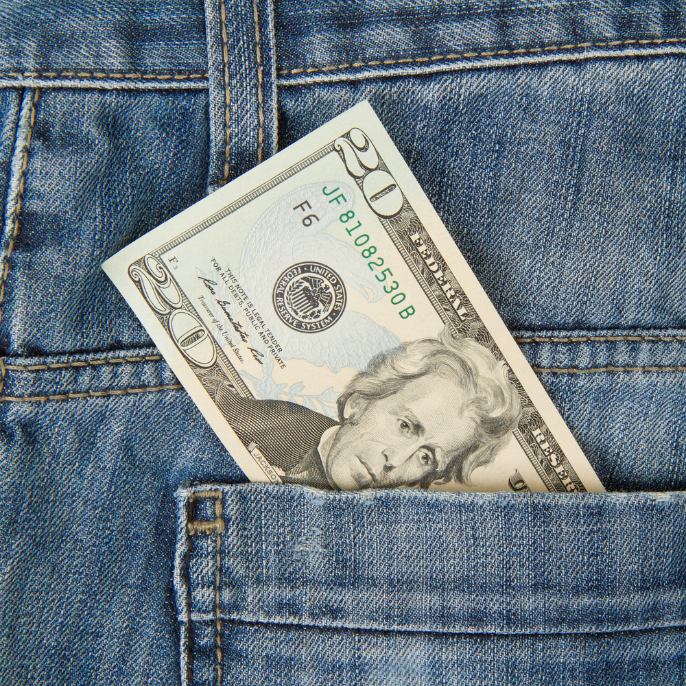 macro shot of trendy jeans with american 20 dollar bill