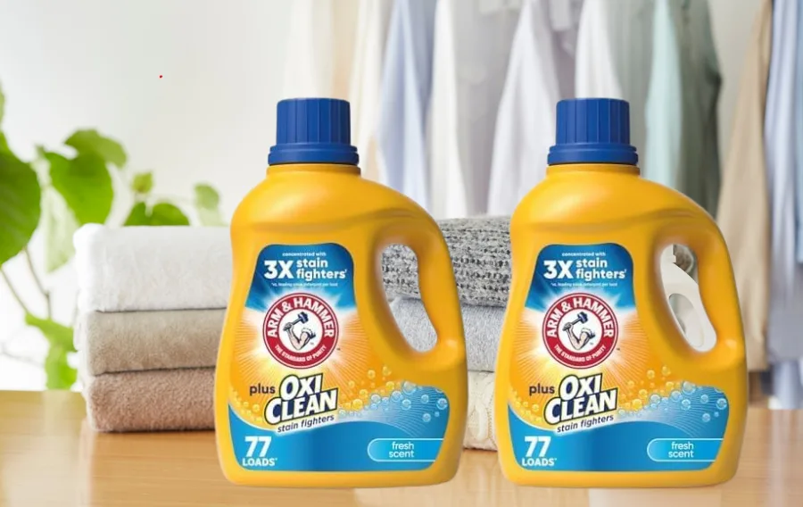 Laundry detergent with towels and clothes in background