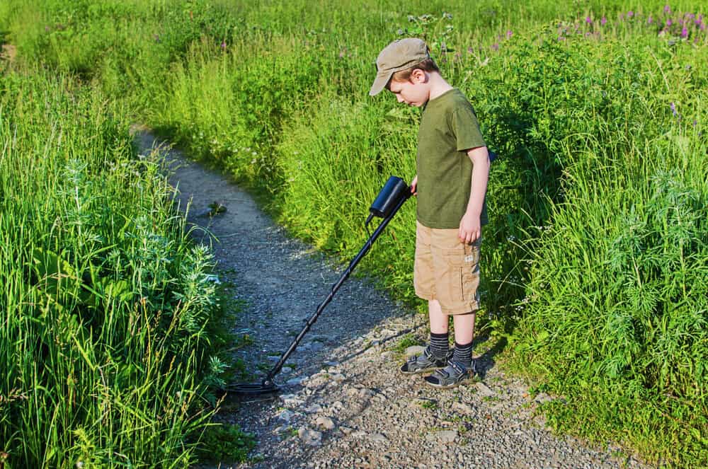 serious boy with a metal detector