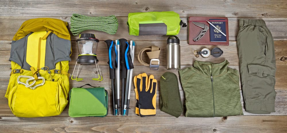 hiking and camping gear organized on rustic wooden boards