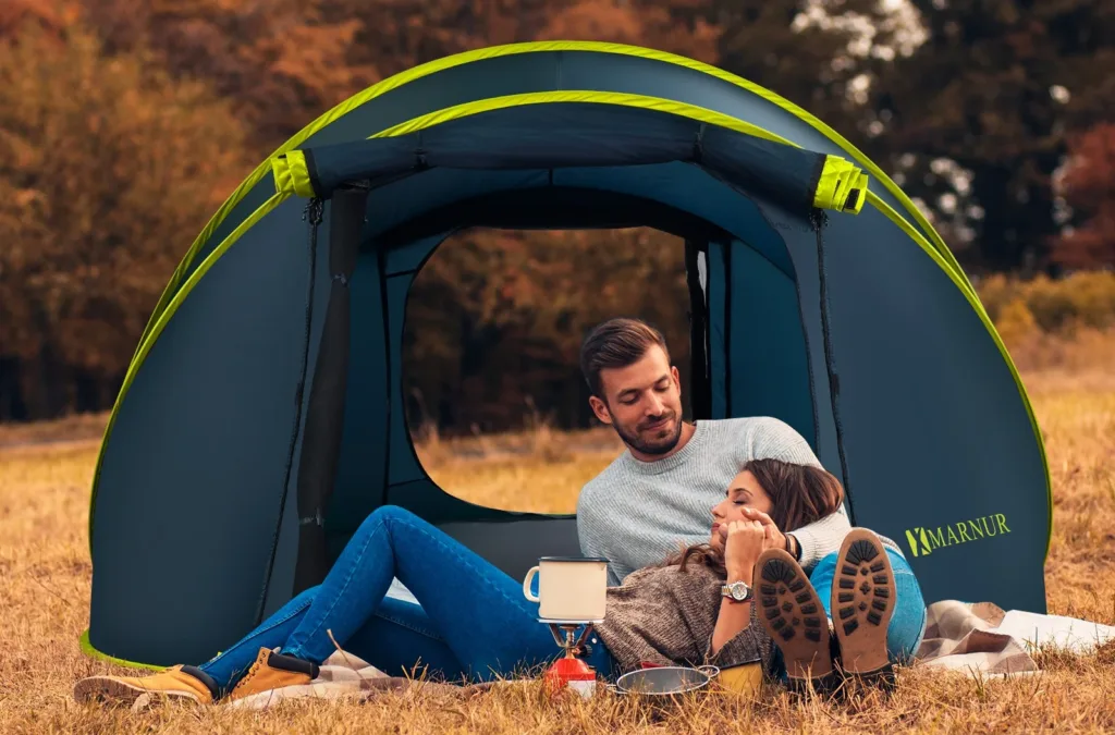 Couple relaxing outside a pop-up tent in autumn.