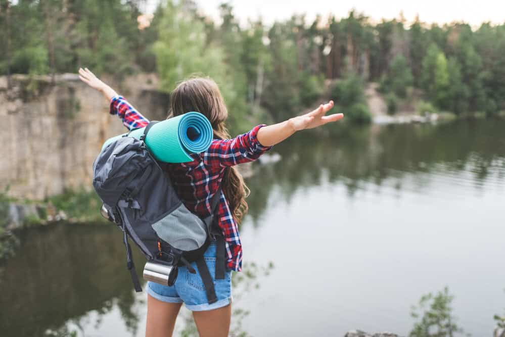 teen hiking with backpack in woods