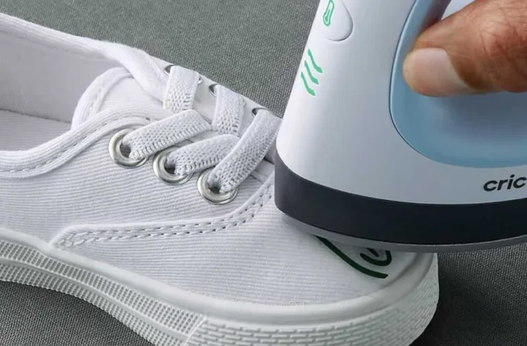 Pressing design onto white sneaker with heat tool.