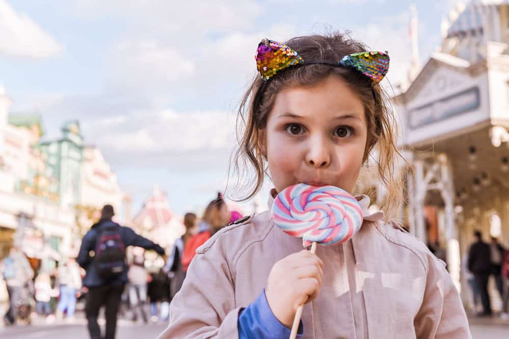 little girl with big lollipop is playing and having fun in the p