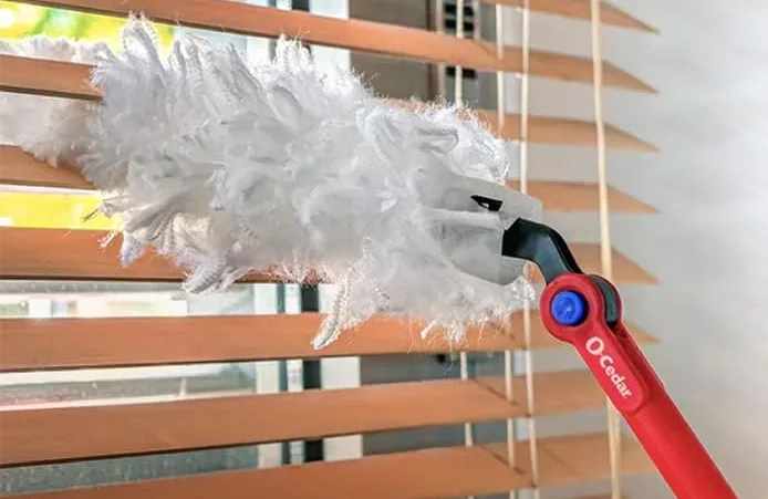 Duster cleaning blinds, effectively trapping more dust.