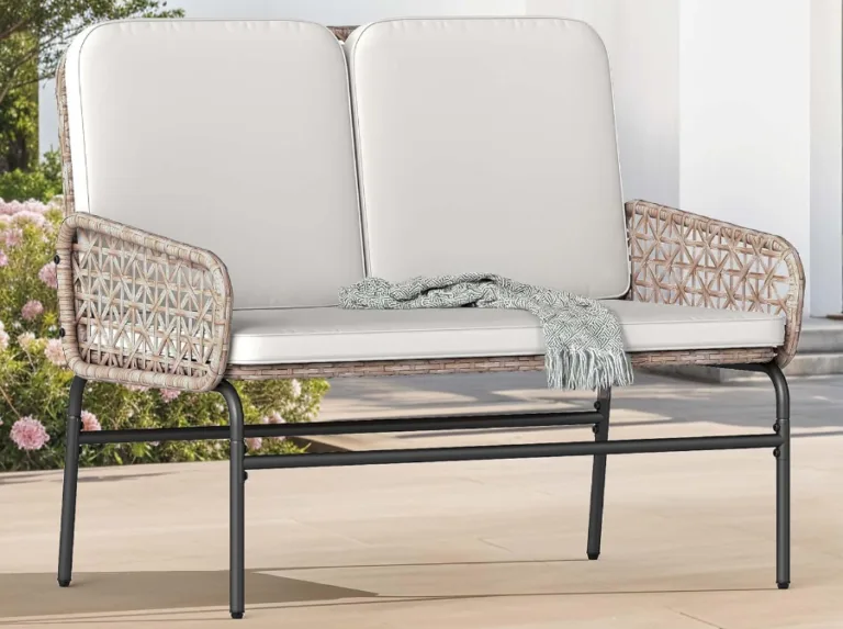 Outdoor rattan loveseat with cushions and blanket
