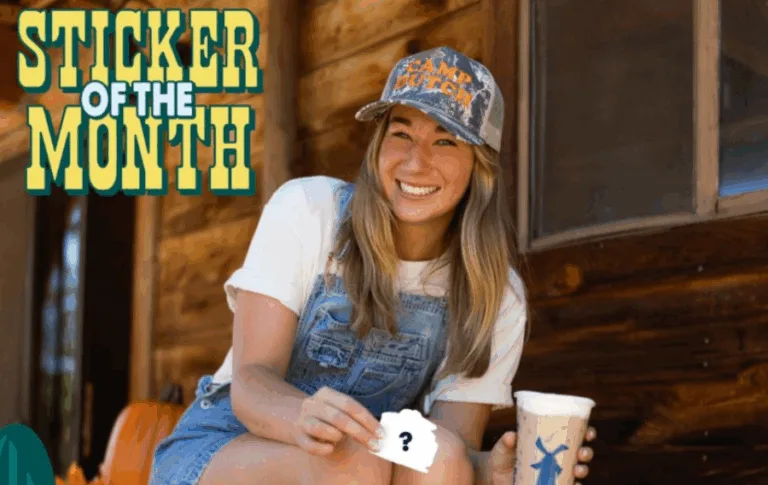 Smiling person with sticker and drink outdoors.