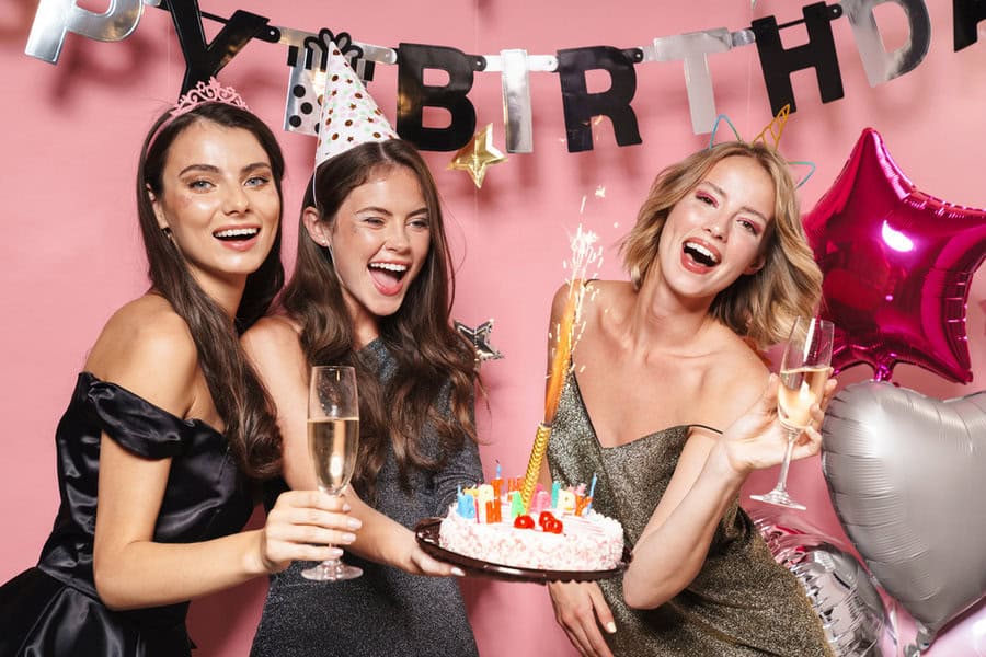 image of joyful party girls holding birthday cake and champagne