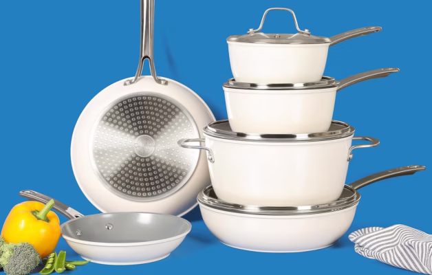 Stacked white cookware set with colorful vegetables.