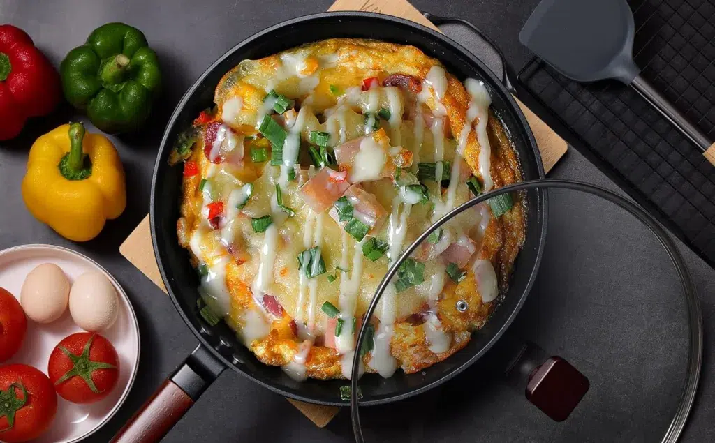 Cheesy vegetable omelette in a frying pan.