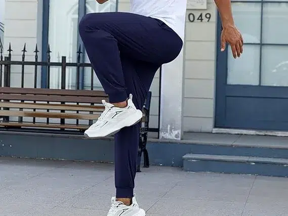 Man in blue joggers, exercising outdoors.
