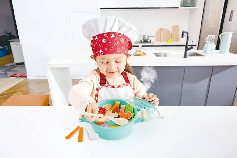 Child cooking with play kitchen set.
