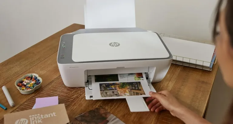 Person using HP printer on wooden desk