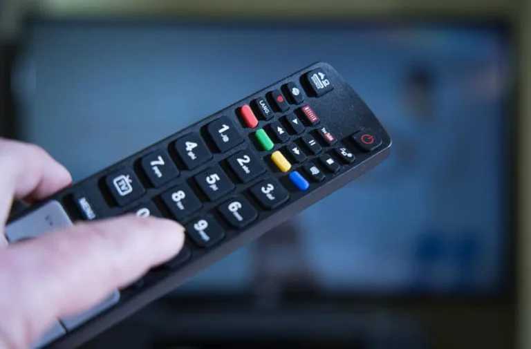 tv remote in use and held by a person