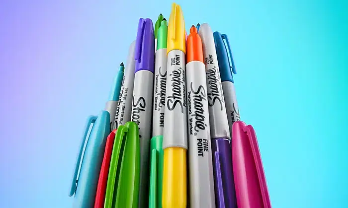 Colorful Sharpie markers against gradient background.