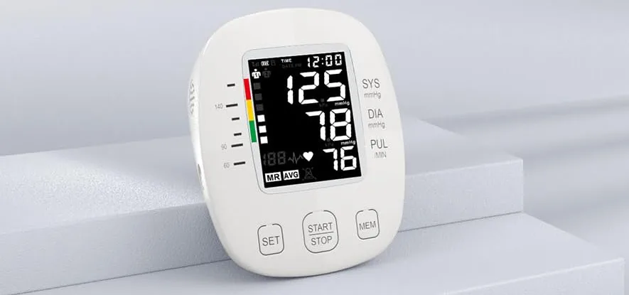 Digital blood pressure monitor on white surface.