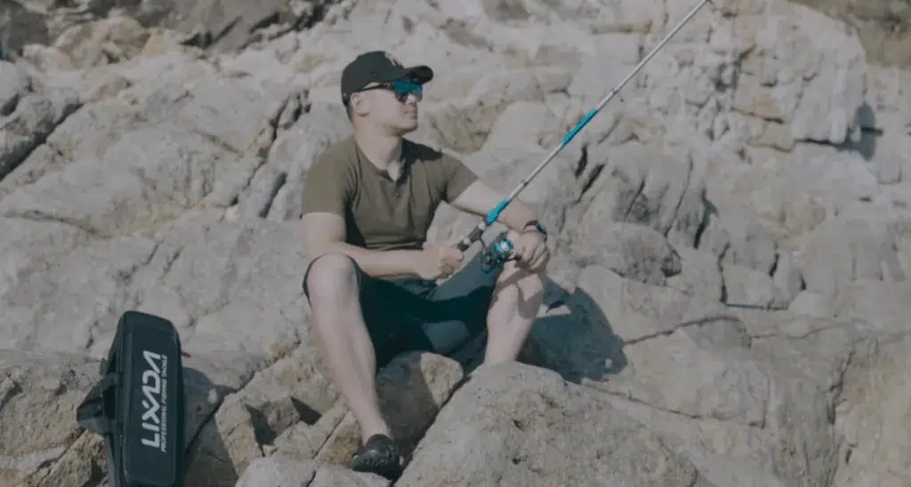 Man fishing on rocky shore