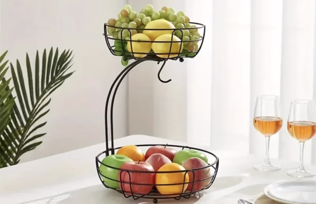 Two-tier fruit basket with assorted fruits.
