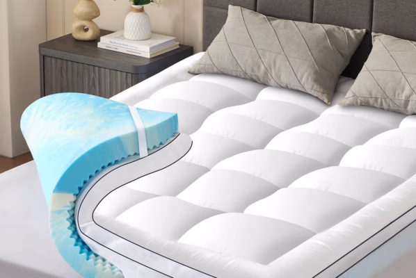 Cooling mattress topper with pillows on bed.