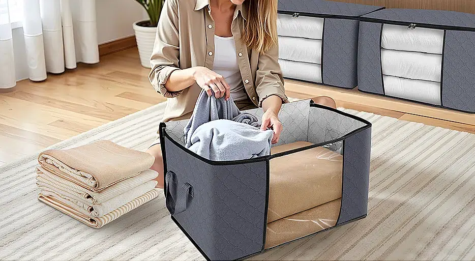 Woman organizing clothes in gray storage bags.