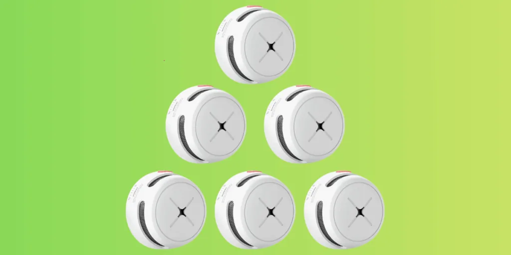 Six smoke detectors against green gradient background.
