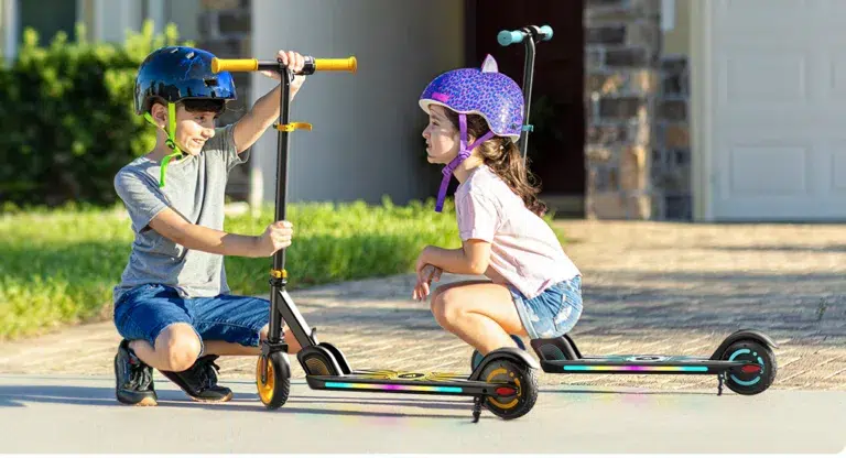 Children enjoying scooter ride wearing helmets.