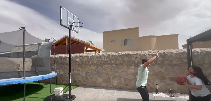 Outdoor basketball game with trampoline nearby