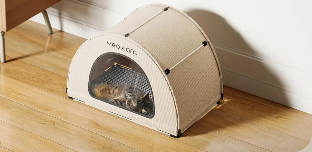 Cat sleeping in cozy pet tent on wooden floor.