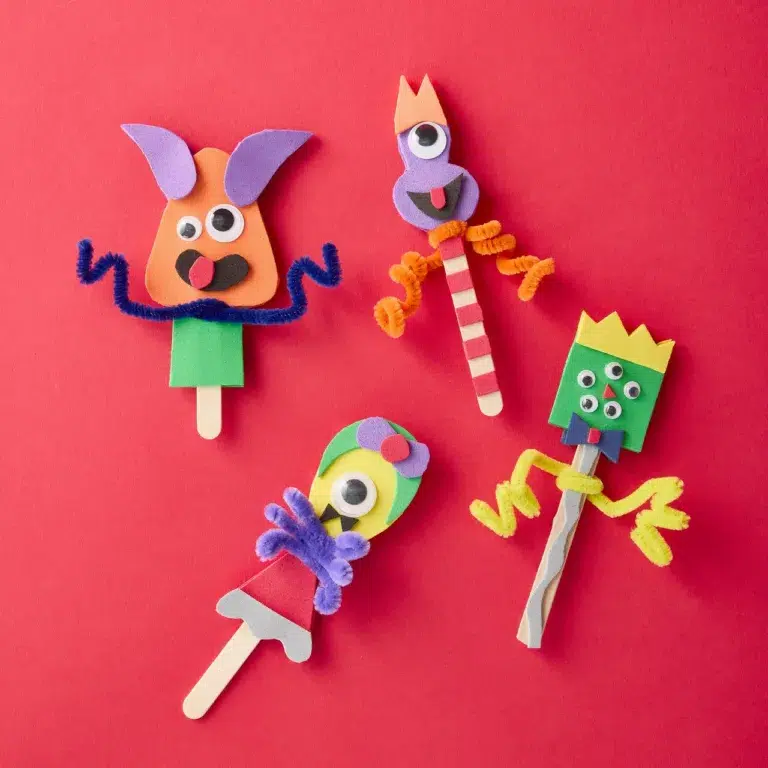 Colorful foam stick puppets on red background.