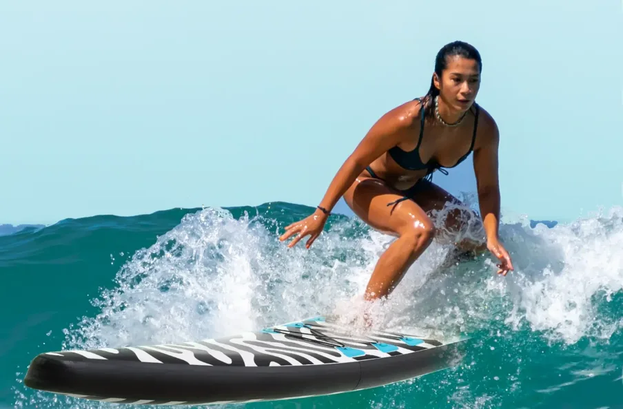 Woman surfing on ocean wave in bikini