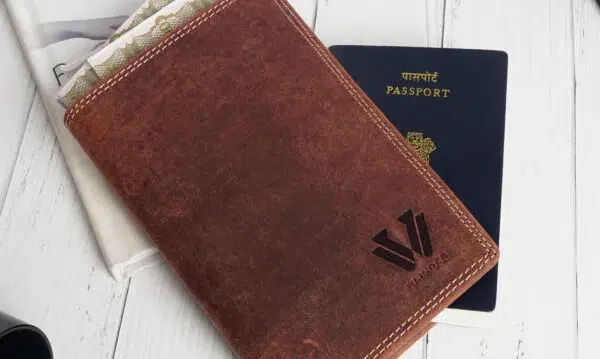 Leather passport holder and passport on table.