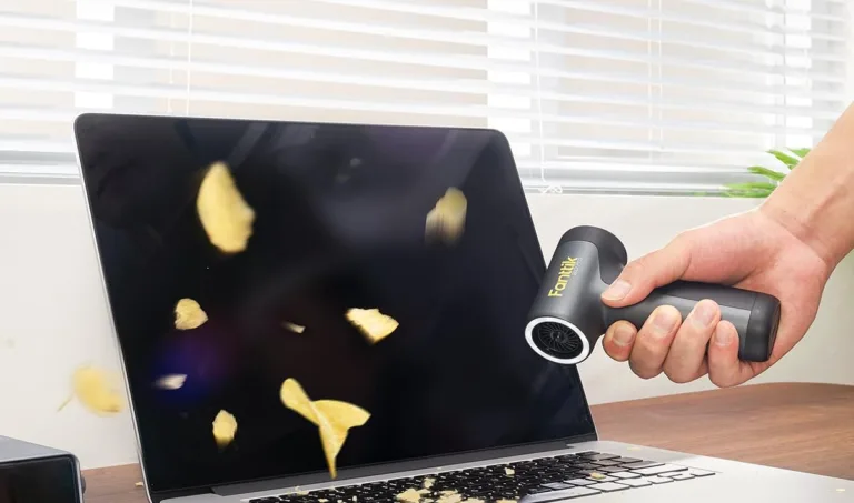 Blowing potato chips off laptop with air blower.