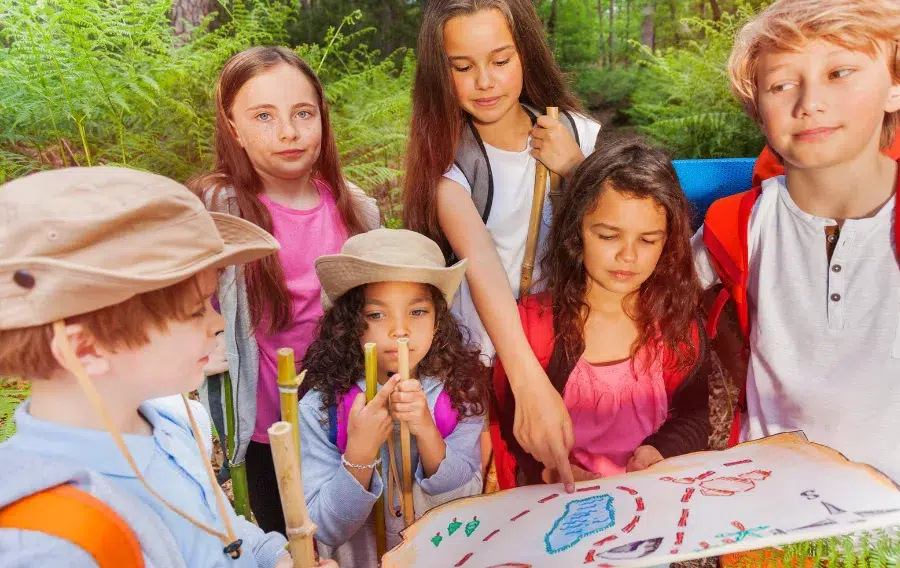 Kids exploring forest with a map together.