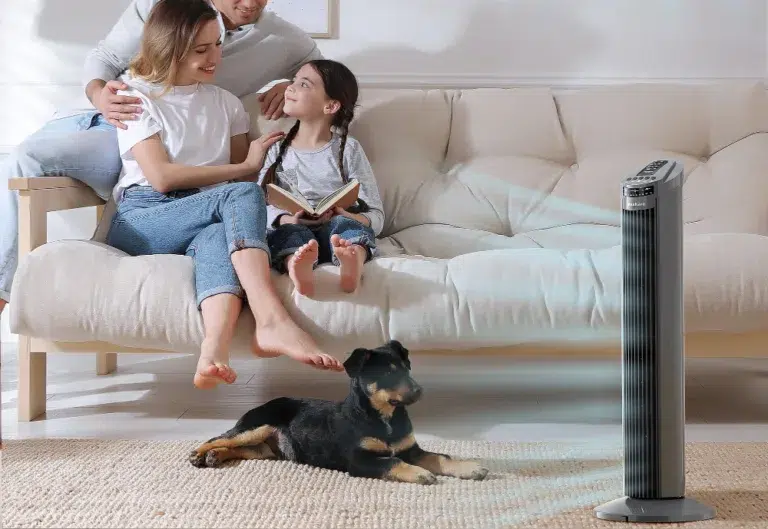 Family relaxing with tower fan and pet dog.